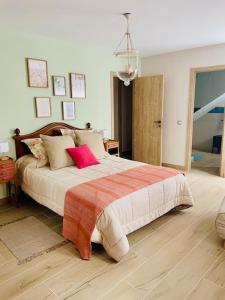 a bedroom with a large bed with red pillows at El Rincón de Victoria y Manolo in Sotillo de la Adrada