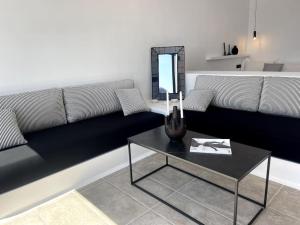a living room with a couch and a table with a mirror at Amenti Horizon View in Agkidia