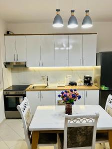 eine Küche mit einem Tisch und einer Blumenvase darauf in der Unterkunft ALBI’S Apartment in Tirana