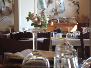 a table with a wine glass with a vase of flowers at Agriturismo Il Cucco in Altedo