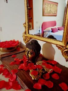 a mirror and a bust and red hearts on a table at Borgo Vecchio in Carbognano