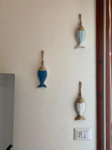 a wall with four vases hanging on a wall at Casa di Jack I.U.N. R6217 in Quartu SantʼElena