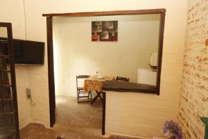 a mirror in a room with a table and a television at Apoena Chales da Ilha in São Francisco Xavier