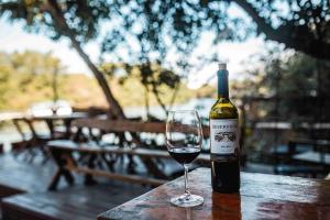 Una botella de vino sentada en una mesa de madera con una copa en Casanova Residence, en Río de Janeiro