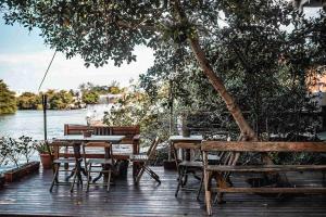 a wooden deck with a table and chairs and a tree at Casanova Residence - Barra da Tijuca na Ilha da Gigoia in Rio de Janeiro