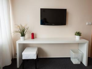 un escritorio blanco con TV en la pared en Hostinec & Vitální svět Raduňka en Opava