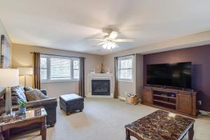 a living room with a couch and a flat screen tv at Rock Island Home with Private Yard and Fire Pit Table! in Rock Island