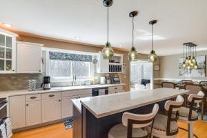 a kitchen with white cabinets and a island with bar stools at Rock Island Home with Private Yard and Fire Pit Table! in Rock Island