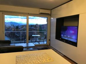 un soggiorno con una grande finestra e una TV di Apartment Aida No1 City view - Free Parking - a Sarajevo
