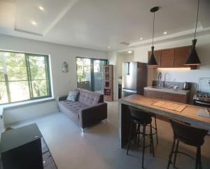 a kitchen and living room with a couch and a table at Casa Buda - Garopaba - SC in Garopaba