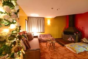 a living room with a fireplace and a christmas tree at Backcountry Lodge Hakuba in Hakuba