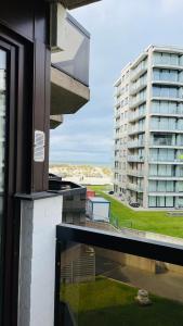 una ventana de un edificio con vistas a un edificio en Studio Sia - Lichtrijke studio met balkon met zijzeezicht in hartje de Panne, en De Panne