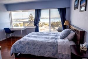 a bedroom with a bed and a large window at HOV B&B House -Hospitality Ocean View Victoria- in Victoria
