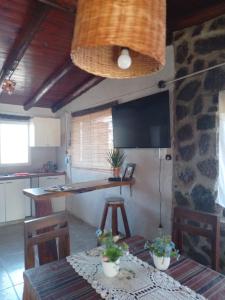 a kitchen with a table with chairs and a television at Cabañas Don Fernando in Santa Rosa de Calamuchita