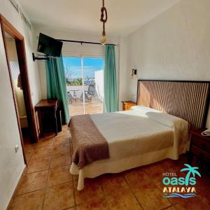 a bedroom with a bed and a view of the ocean at Hotel Oasis Atalaya in Conil de la Frontera
