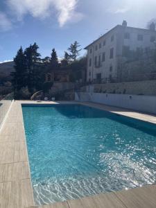 una piscina con acqua blu di fronte a un edificio di Villa Allegrini a Segni
