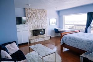 a bedroom with a bed and a stone fireplace at HOV B&B House -Hospitality Ocean View Victoria- in Victoria