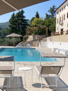 uma piscina com mesas e cadeiras ao lado de um edifício em Villa Allegrini em Segni