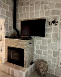 a stone fireplace with a flat screen tv on a wall at Villa Brachychiton in Ostuni +88 photos