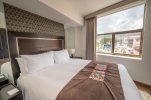 1 dormitorio con 1 cama grande y ventana grande en Hotel Jose Antonio Cusco, en Cusco