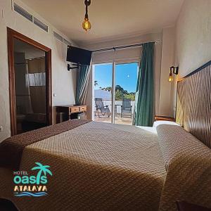 a bedroom with a bed with a view of the ocean at Hotel Oasis Atalaya in Conil de la Frontera
