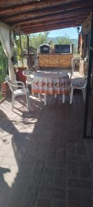 um pátio com uma mesa, cadeiras e comodidades para churrascos em Cabañas Don Fernando em Santa Rosa de Calamuchita