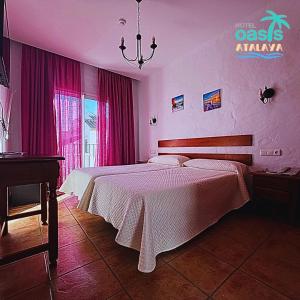コニル・デ・ラ・フロンテーラにあるHotel Oasis Atalayaのピンクの壁のベッドルーム1室(大型ベッド1台付)