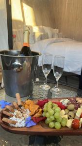 una mesa con un plato de comida y dos copas de vino en Hostería y Cabañas Villa Alejandra en Máfil