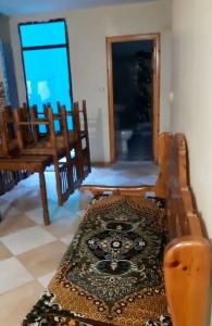 sala de estar con sillas de madera y alfombra en Jijel location F3 avec piscine plein air, en Jijel