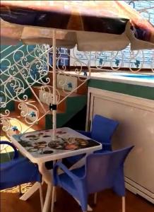 Jijel location F3 avec piscine plein air في جيجل: طاولة وكراسي مع طاولة ومظلة