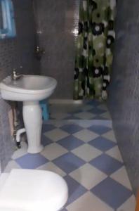 a bathroom with a white sink and a toilet at Jijel location F3 avec piscine plein air in Jijel