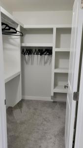 a closet with white shelves and a curtain at Sunny Perch Stay in Edmonton