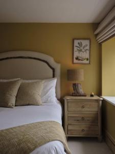 a bedroom with a bed and a night stand with a lamp at Plum House in Haslemere