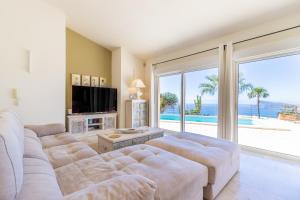 a living room with a large couch and a large window at Altea Hills , Villa Noruega in Altea