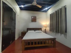 a bedroom with a bed and a ceiling fan at Sukūn Heritage -A traditional 4 Bedroom Vacation Villa in Kannur