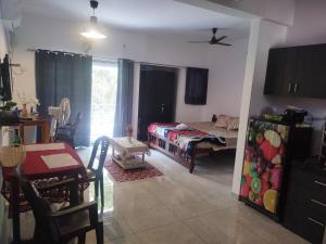 een woonkamer met een bed en een eetkamer bij Palolem plaza in Canacona