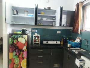 een keuken met een koelkast gevuld met veel fruit bij Palolem plaza in Canacona