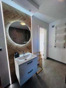 a bathroom with a sink and a mirror on the wall at Apartamenty na Nadmorskiej in Władysławowo