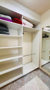 a walk in closet with white shelves at Cantinho Paz e Amor in Nova Petrópolis