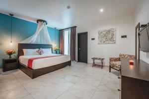 a bedroom with a king sized bed and a couch at Soho Playa Hotel in Playa del Carmen