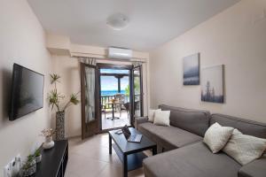 a living room with a couch and a table at Iakovakis Seaside Exclusive Apartments in Koropi