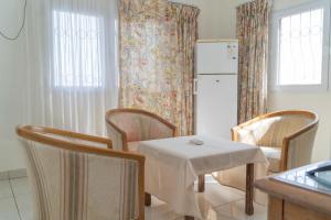 a kitchen with a table and chairs and a refrigerator at Hotel Azur Conakry in Conakry