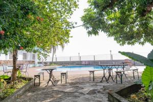 a group of tables and chairs next to a pool at Hotel Azur Conakry in Conakry