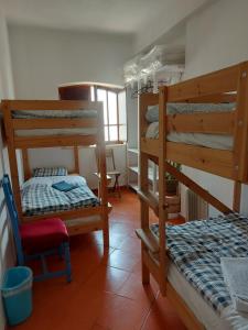 a room with a bunk bed and a bed and a chair at Agua de Sonho 2 in Bensafrim