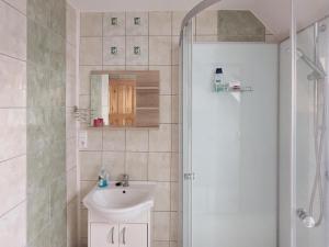 a white bathroom with a sink and a shower at Apartmány u Bernardů in Stožec