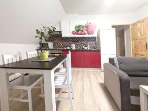 a kitchen and living room with a table and a couch at Apartmány u Bernardů in Stožec