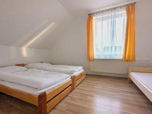 two beds in a room with a window at Apartmány u Bernardů in Stožec