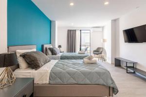 イラクリオン・タウンにあるMaricool Minimal Spacious Downtown Loftのベッド2台と薄型テレビ付きのベッドルーム