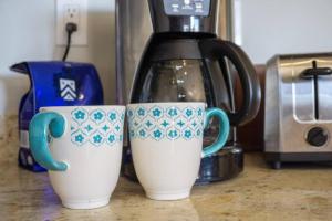 San Carlosにある1C Casa 1 Sea Penthouse, Cerritos Beach Condoのカウンターの横に座るカップ2杯