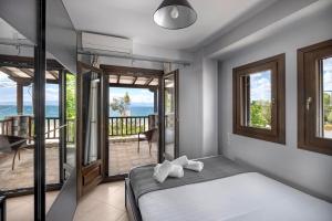 a bedroom with a bed and a balcony at Iakovakis Seaside Exclusive Apartments in Koropi